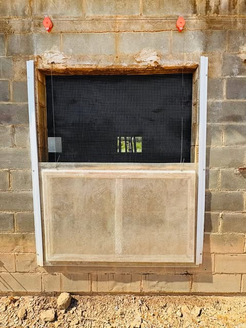 Ventana de una nave ganadera renovada con tela pajarera